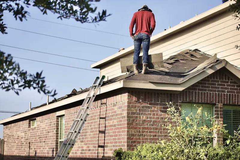 Professional roofer working on a residential roof in Monte Vista